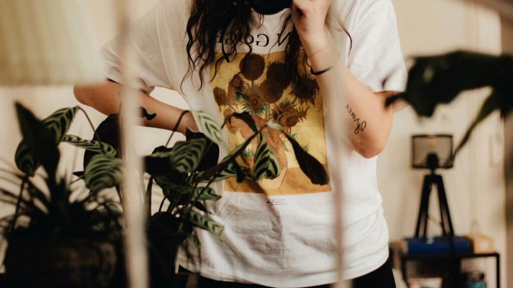 woman in white t-shirt holding green plant